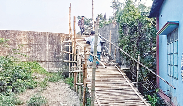বাঁশের সাঁকো বেয়ে উঠতে হয় ১০ কোটি টাকার সেতুতে বাঁশের সাঁকো বেয়ে উঠতে হয় ১০ কোটি টাকার সেতুতে
